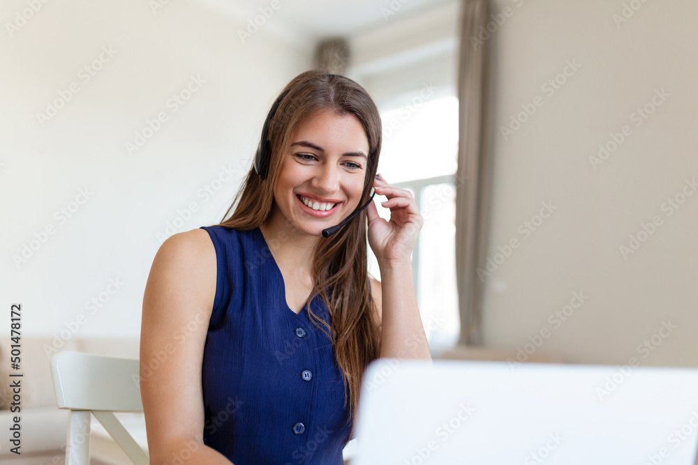 Happy young woman in headphones speaking looking at laptop making notes, business woman talking by video conference call, Conference by webcam, online training, e-coaching concept Happy young woman in headphones speaking looking at laptop making notes, business woman talking by video conference call, Conference by webcam, online training, e-coaching concept