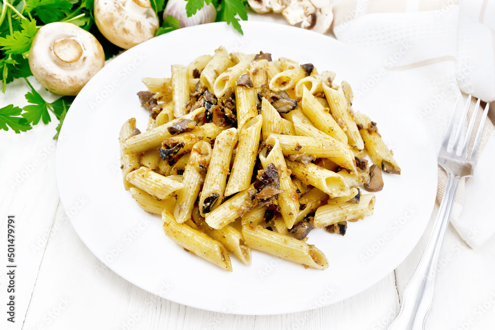 Pasta with mushrooms in white plate on wooden board