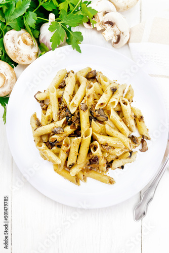 Pasta with mushrooms in white plate on light board top