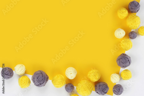 Background of balls of yarn for knitting or crocheting gray and yellow on a yellow background.The concept of manual labor, crafts, hobbies,banner for yarn sale.Copyspace.