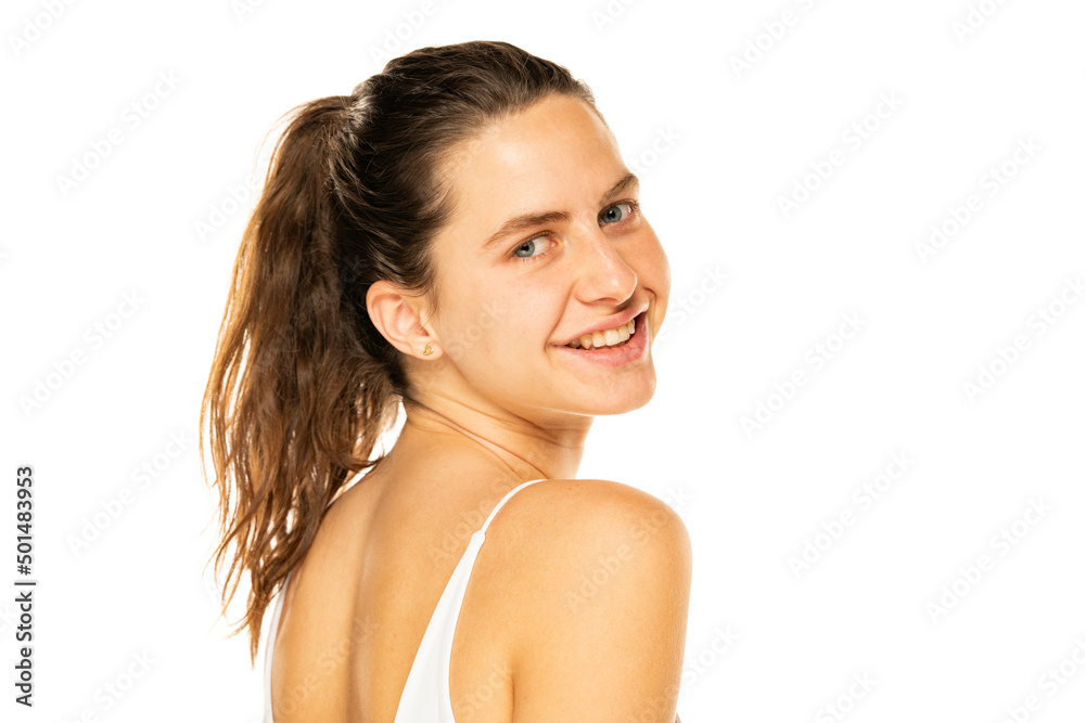 Portrait of a young smiling woman with ponytail and without makeup on a white background Portrait of a young smiling woman with ponytail and without makeup on a white background