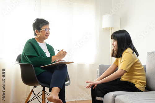 Depressed asian girl having consultation with psychologist at clinic.