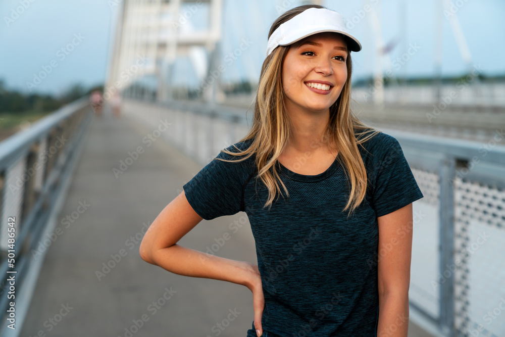 YYoung smiling satisfied fit woman resting after an active fitness training outdoors in city YYoung smiling satisfied fit woman resting after an active fitness training outdoors in city
