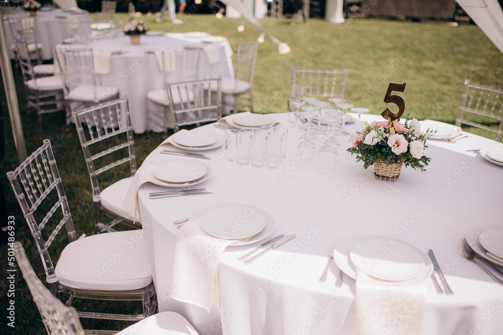 Fototapeta premium banquet table setting under a white tent on the grass