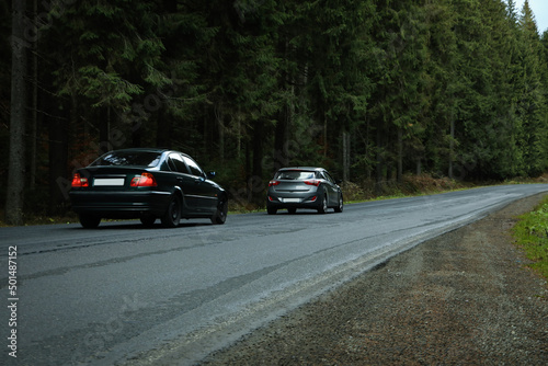 Travel concept  cars drive along the road in the forest