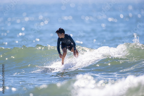 湘南の海でサーフィンをする少年
