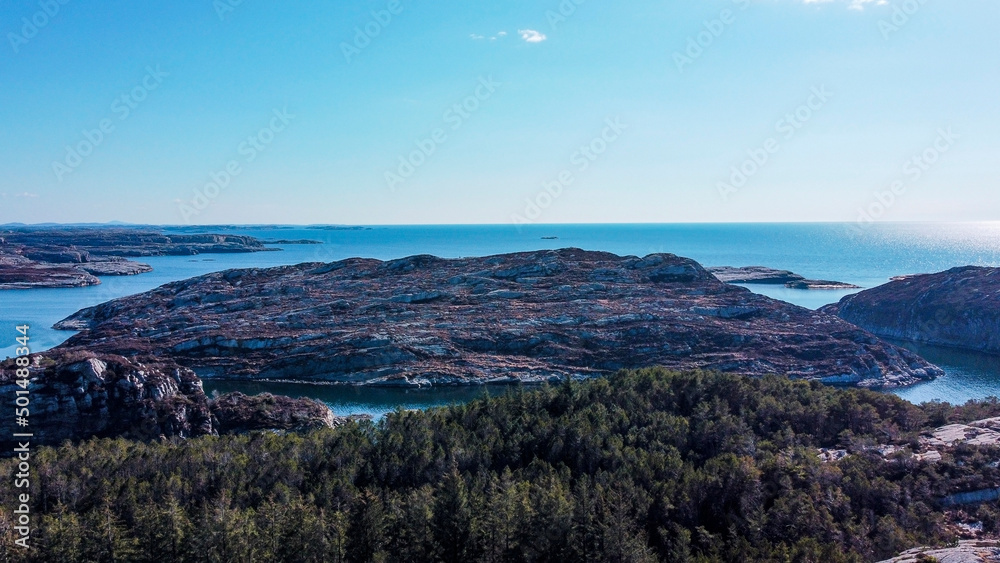 Aerial view of the sea wave and rocks of the coastline of Norway, Telavåg. Panoramic view of the rocks by the sea. The sea wave rolls along the shore. View of the sea coast from the air. Ocean space