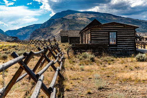 Old western house in a field with mountains in the background in Cody, Wyoming photo