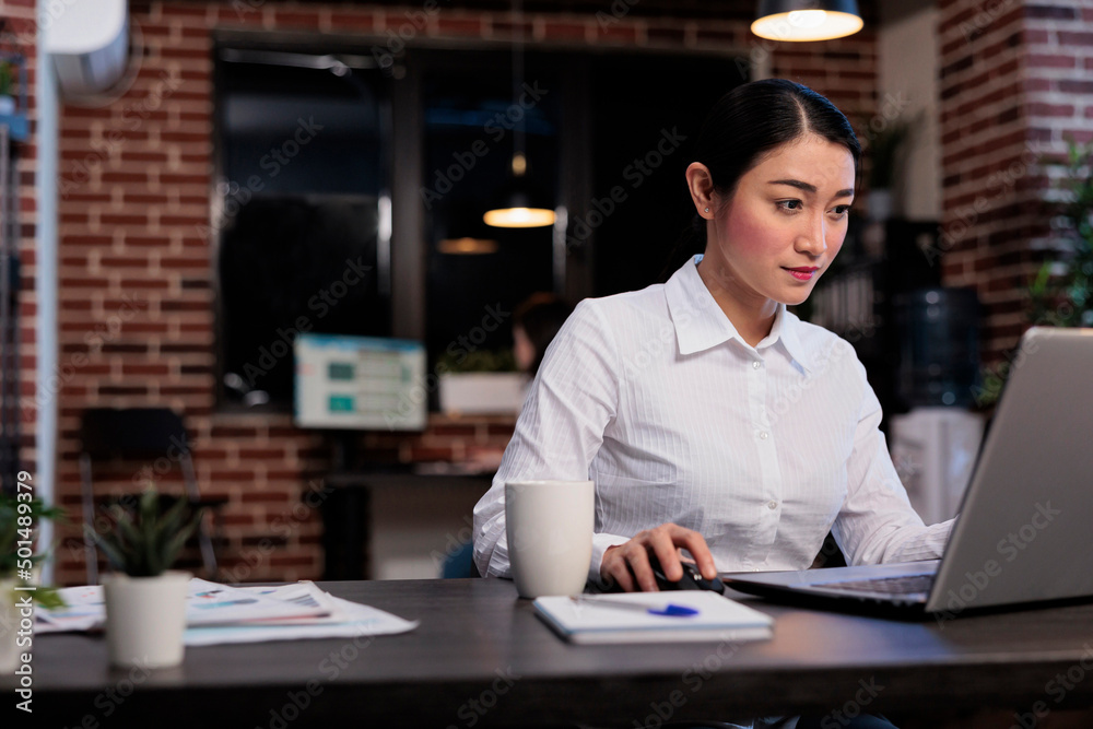 Marketing company employee sitting at desk in office while developing management plan. Executive manager working on computer laptop while analyzing accounting data and financial strategy. Marketing company employee sitting at desk in office while developing management plan. Executive manager working on computer laptop while analyzing accounting data and financial strategy.