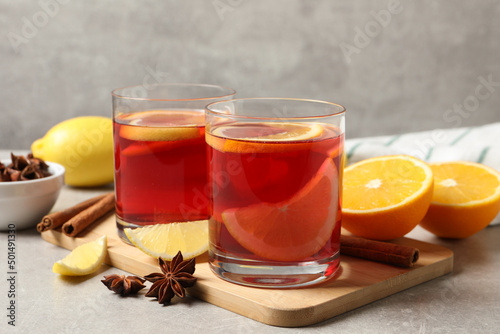Aromatic punch drink and ingredients on grey table