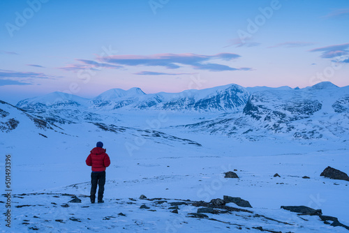 Foto A man enjoying the view over the snow covered mountains in Swedish Lapland