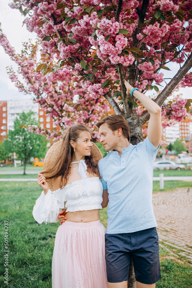 Amazing young couple hugging near sakura trees Amazing young couple hugging near sakura trees