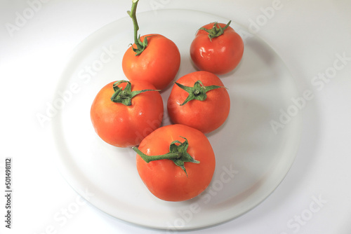 Photography Closeup of coppery tomatoes on a white plate