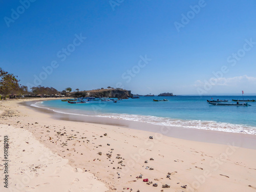 An areal  drone shot with a view on an idyllic Pink Beach on Lombok  Indonesia. Many boats drifting on a calm surface of the sea. Unspoiled  hidden gem. Perfect place for peaceful  relaxed holidays