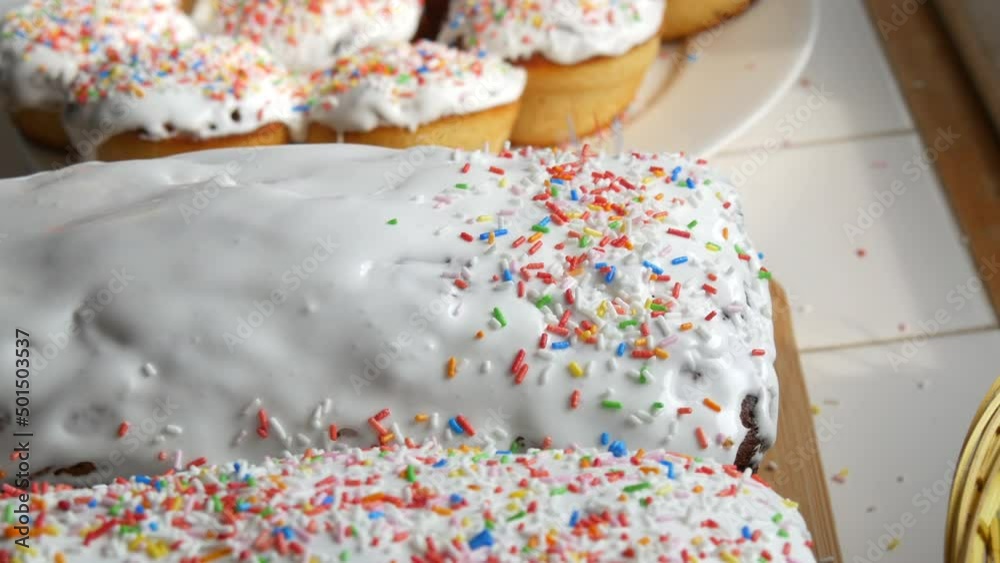 Easter cake with white glaze. Hand sprinkles with multi-colored powder. Easter Traditions in Eastern Europe Easter cake with white glaze. Hand sprinkles with multi-colored powder. Easter Traditions in Eastern Europe