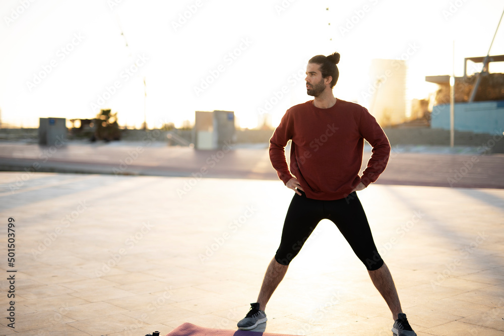 Fitness training outdoors. Handsome man working exercises in early morning. Muscular man training outside..