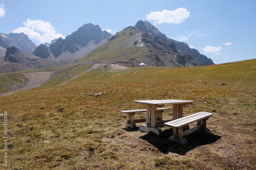 wooden table and benches on a background of mountains