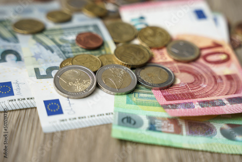 Euro Geldmünzen und Geldscheine auf einem Holz Tisch. Nahaufnahme, Bargeld.