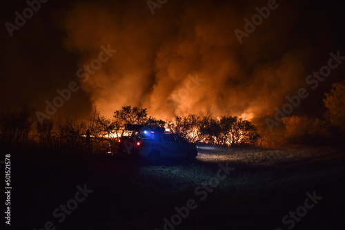 Bomberos trabajando durante un incendio forestal. Fuego y llamas amenazan el bosque, los arboles y el medio ambiente, Noche y llamas, riesgo y personal de emergencias.

