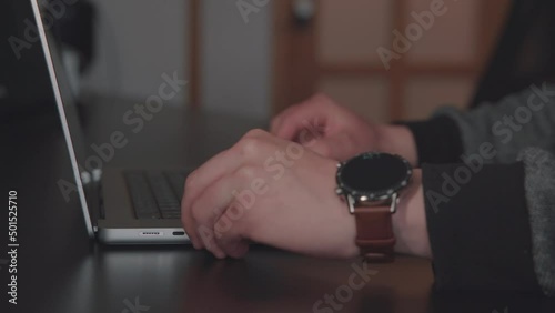 Man opens laptop, inserts reduction with cable into usb c port, write on the keyboard and closes laptop in the office