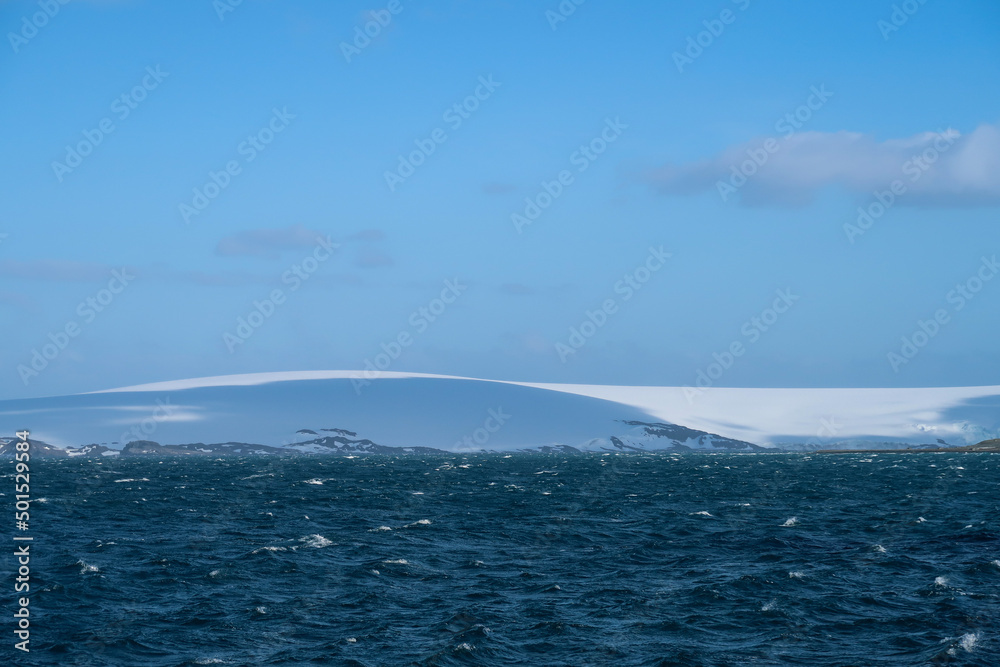 Obraz premium Huge hills covered in snow and ice and the Antarctic ocean visible in the distance