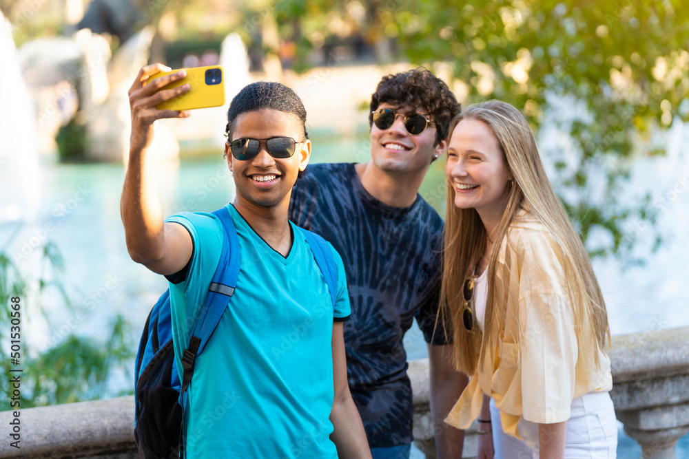 Obraz premium Group of young friends taking a selfie on vacation visiting a landmark.