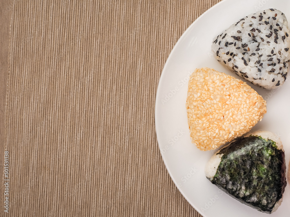 A series of shots of onigiri of various shapes and fillings on a plate. Top view. Japanese rice ball.