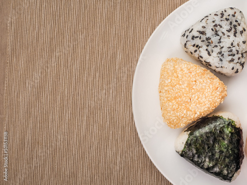A series of shots of onigiri of various shapes and fillings on a plate. Top view. Japanese rice ball.