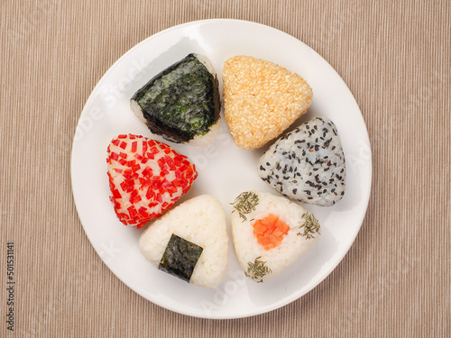 A series of shots of onigiri of various shapes and fillings on a plate. Top view. Japanese rice ball.