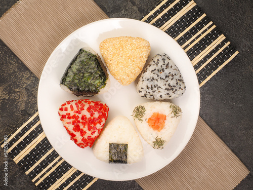 A series of shots of onigiri of various shapes and fillings on a plate. Top view. Japanese rice ball. photo