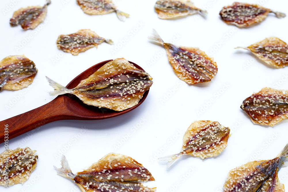 Dried fish with sesame seeds on white background. Dried fish with sesame seeds on white background.