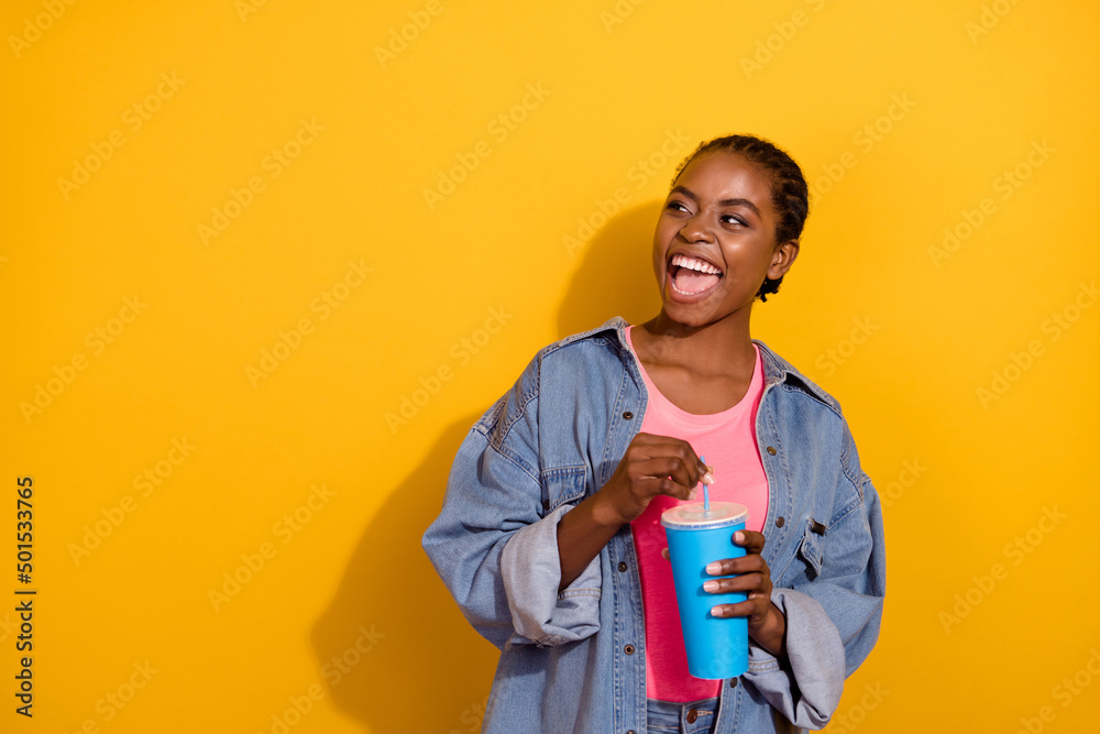 Photo of young excited lady curious look empty space drink cola unhealthy isolated over yellow color background