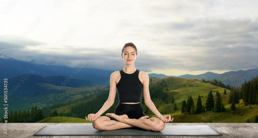Young woman practicing yoga on wooden surface against beautiful mountain landscape. Banner design
