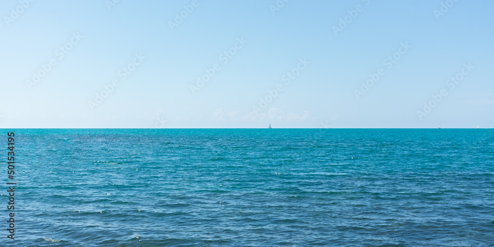 Obraz premium Sea horizon banner. Bright turquoise sea on a hot sunny summer day. Vacation concept. vacations'. travel and relaxation. Pleasure boats on the horizon. Minimalism in nature. Horizontal background