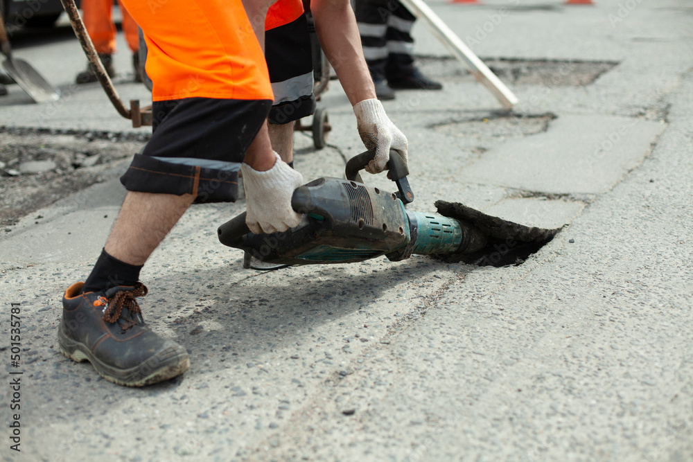 He removes the asphalt with a jackhammer. Removing the asphalt layer from the road. He removes the asphalt with a jackhammer. Removing the asphalt layer from the road.