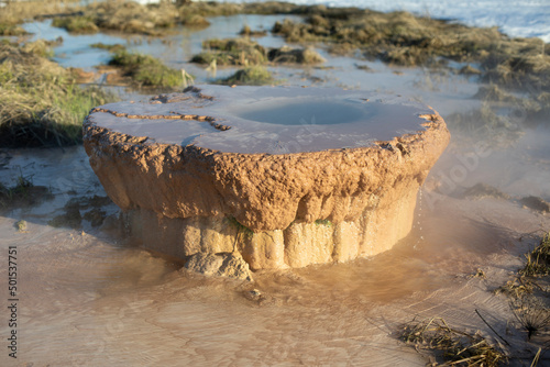 Pipe with waste in nature. Rusty pipe out of ground. Environmental problem.