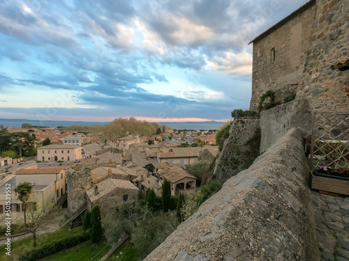 Panoramic view of the old famous city of Bolsena and Lake Bolsena at sunset. Province of Viterbo, Italy, Lazio. Cityscape and tiled roofs