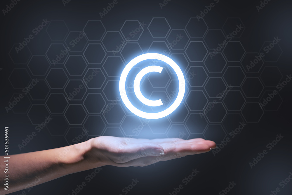 The concept of copyright and intellectual property as a projection of a hologram on the hand. The concept of copyright and intellectual property as a projection of a hologram on the hand.