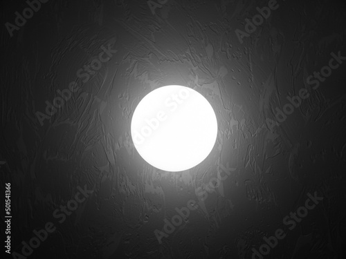 Abstract glowing sphere on the wall in a dark room.