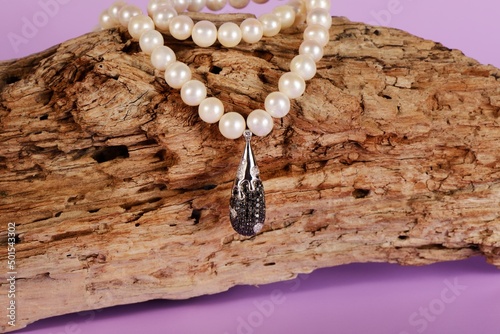 Women's platinum pendant with a black and white diamonds on a preciouse pearls necklace