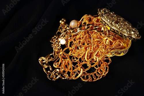 Lots of golden jewelry over a black background