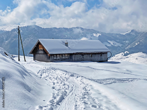 Indigenous alpine huts and wooden cattle stables on Swiss pastures covered with fresh white snow cover  Nesslau - Obertoggenburg  Switzerland  Schweiz 