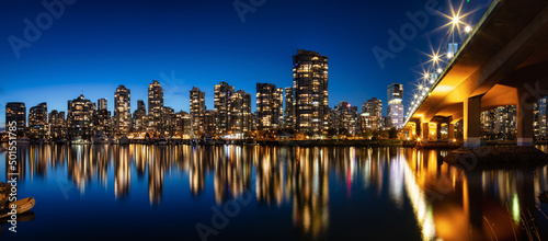 Cambie Bridge in False Creek with modern city buildings at night after sunset. Downtown Vancouver Cityscape, British Columbia, Canada. Panorama