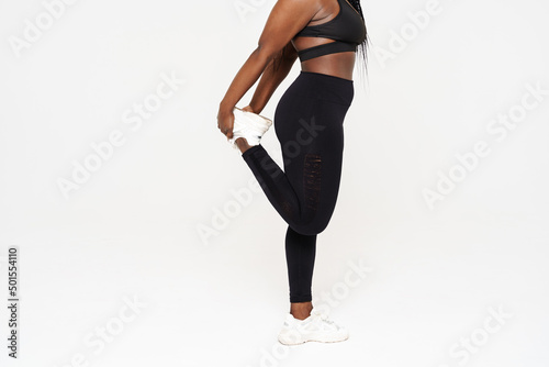 Young black sportswoman doing exercise while working out
