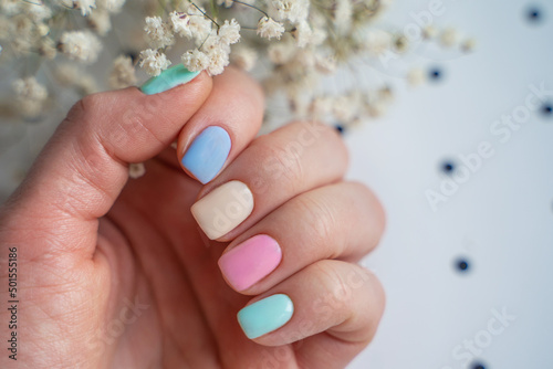 well-groomed, manicured bride fingers in pastel colors of the hand