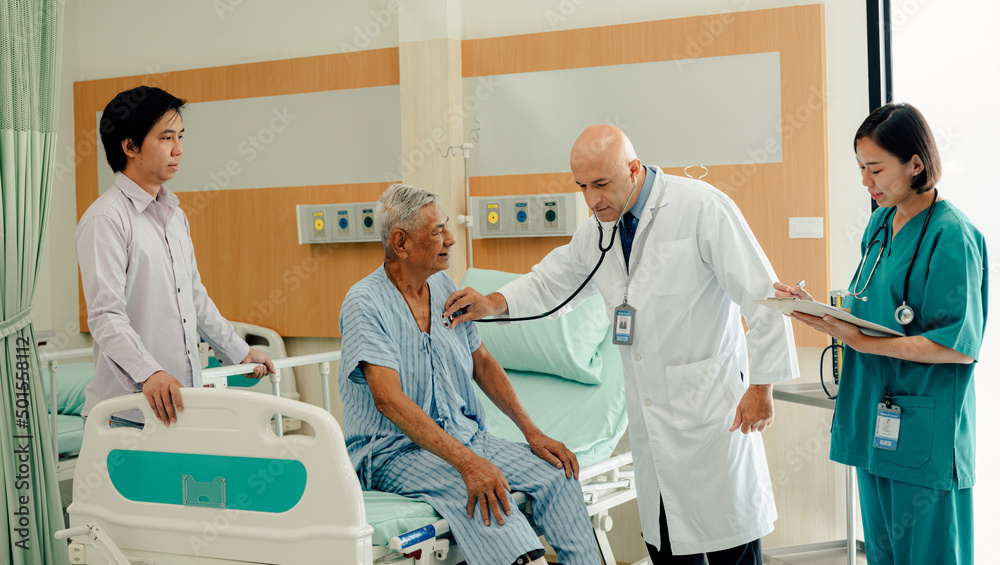 Obraz premium Hospitalized man sitting in bed while doctor checking his pulse. Doctor examining senior male patient in hospital room.