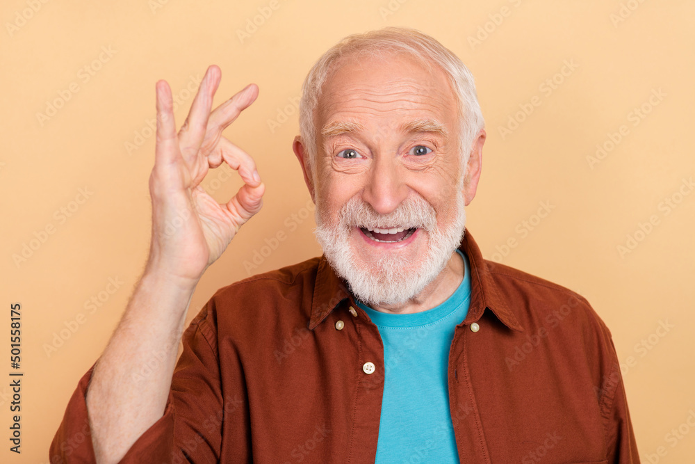 Photo of excited cheerful grandfather showing okay symbol advertisement promotion isolated on beige color background Photo of excited cheerful grandfather showing okay symbol advertisement promotion isolated on beige color background