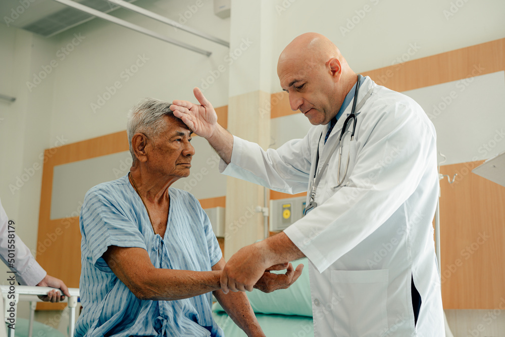 Obraz premium Hospitalized man sitting in bed while doctor checking his pulse. Doctor examining senior male patient in hospital room.