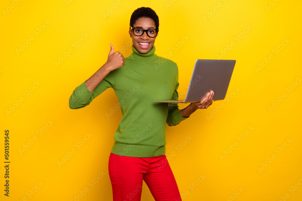 Photo of clever cool trans woman wear green turtleneck working modern device thumb up isolated yellow color background Photo of clever cool trans woman wear green turtleneck working modern device thumb up isolated yellow color background