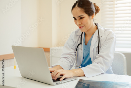 Asian woman doctor in uniform greeting patients online on laptop during on line meeting.